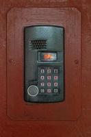 an intercom on old painted brown steel surface with a keypad, digital display and rfid sensor for calling close-up photo