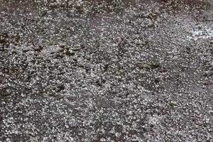 granizo de hielo blanco en la superficie de la carretera asfaltada foto