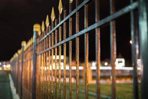 black iron forged fence at night with selective focus and boke blur photo