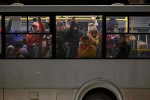 Tula, Russia May 9, 2021 Crowd of people in white public bus at spring night, side view from outside photo