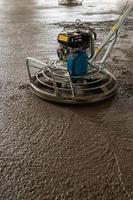 Power float grinder machine on wet concrete background closeup photo