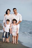 familia joven feliz divertirse en la playa foto