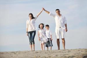 family on beach showing home sign photo