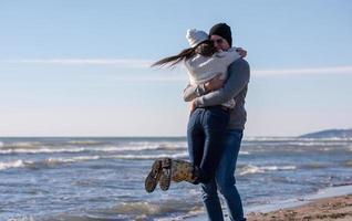 amorosa pareja joven en una playa en el día soleado de otoño foto