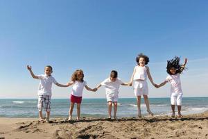 happy child group playing  on beach photo