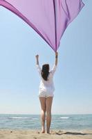 beautiful young woman on beach with scarf photo