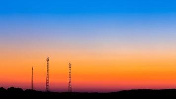 torres de comunicación lejos en el fondo del cielo del amanecer foto