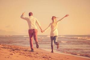 Loving young couple on a beach at autumn sunny day photo