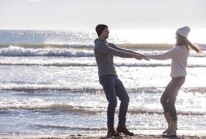 Loving young couple on a beach at autumn sunny day photo