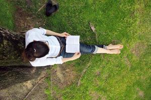 Young woman reading a book in the park photo