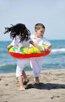 Grupo de niños felices jugando en la playa foto