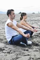 pareja yoga playa foto