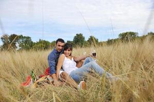 pareja feliz disfrutando de un picnic en el campo en hierba larga foto