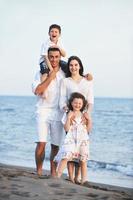 familia joven feliz divertirse en la playa foto