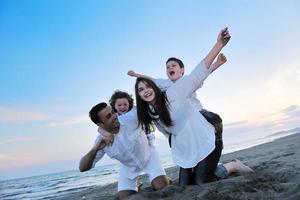 familia joven feliz divertirse en la playa foto