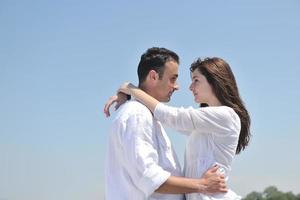 feliz pareja joven divertirse en la playa foto