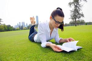 mujer joven leyendo un libro en el parque foto
