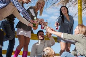 Group of friends having fun on autumn day at beach photo