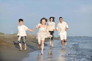 happy young family have fun on beach at sunset photo