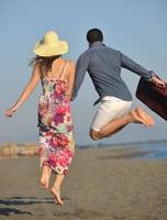 couple on beach with travel bag photo