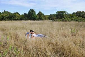 happy couple enjoying countryside picnic in long grass photo