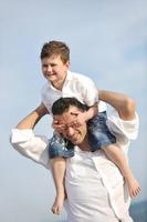 happy father and son have fun and enjoy time on beach photo