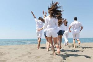 grupo de gente feliz divertirse y correr en la playa foto