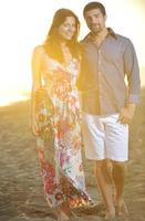 feliz pareja joven tiene tiempo romántico en la playa foto