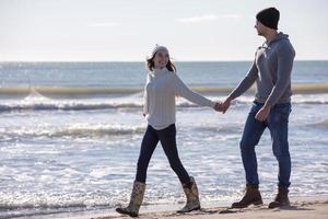 Loving young couple on a beach at autumn sunny day photo