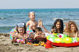 grupo infantil divertirse y jugar con juguetes de playa foto