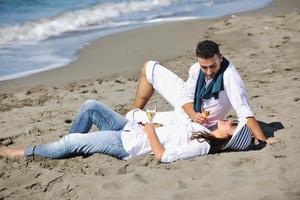 pareja joven disfrutando de un picnic en la playa foto