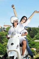 Portrait of happy young love couple on scooter enjoying summer time photo