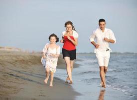 familia joven feliz divertirse en la playa foto