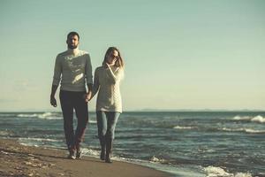 Loving young couple on a beach at autumn sunny day photo