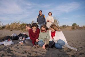 Friends having fun at beach on autumn day photo