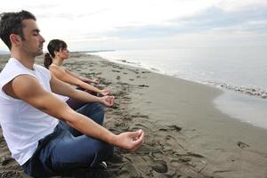 pareja yoga playa foto