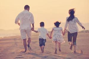 happy young family have fun on beach at sunset photo