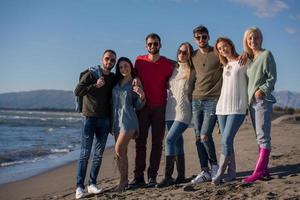 portrait of friends having fun on beach during autumn day photo