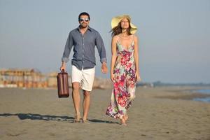 pareja en la playa con bolsa de viaje foto