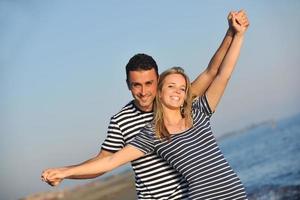 feliz pareja joven tiene tiempo romántico en la playa foto