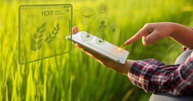 agricultor de tecnología agrícola que tiene tableta digital o tecnología de tableta para investigar sobre datos de análisis de problemas agrícolas e icono visual. granjero agrícola inteligente que usa internet de las cosas foto