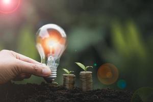 alternative energy, Renewable Energy, saving energy, electricity light lamp from solar and finance, finance banking growth, energy stock investment, tree growing up on coin and lightbulb on soil photo