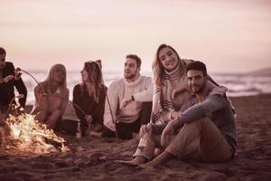 Group Of Young Friends Sitting By The Fire at beach photo