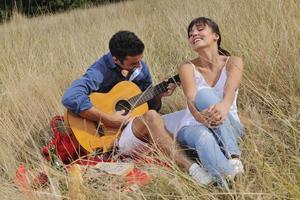 pareja feliz disfrutando de un picnic en el campo en hierba larga foto