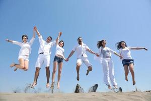 grupo de gente feliz divertirse y correr en la playa foto