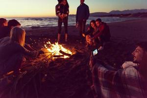 Friends having fun at beach on autumn day photo