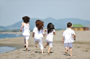 Grupo de niños felices jugando en la playa foto