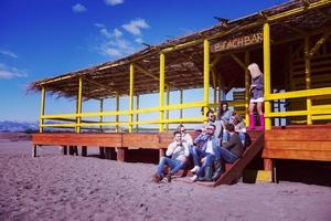 grupo de amigos divirtiéndose el día de otoño en la playa foto