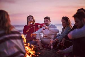 Group Of Young Friends Sitting By The Fire at beach photo