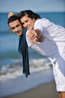 feliz pareja joven divertirse en la hermosa playa foto